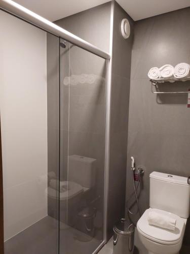 a bathroom with a toilet and a glass shower stall at Golden Gramado Resort in Gramado
