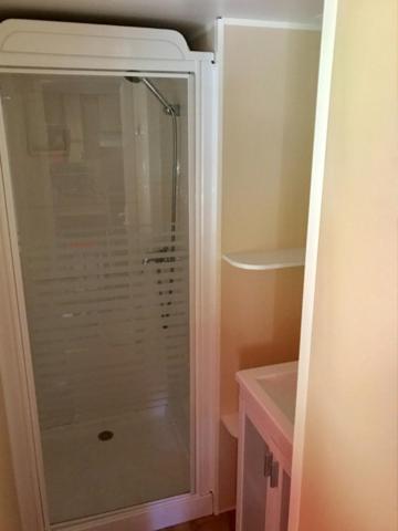 a shower with a glass door in a bathroom at Camping de Pujol - Chalets - Argeles sur Mer - Lotus - 6P in Argelès-sur-Mer