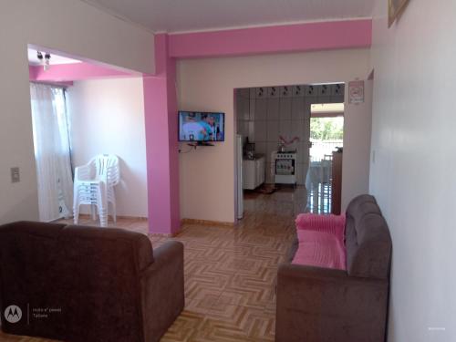 a living room with two couches and pink walls at Apart Hotel Esperança in Ametista do Sul