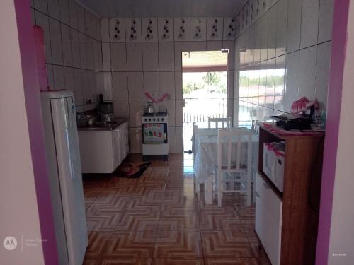 una cocina con electrodomésticos blancos y una mesa. en Apart Hotel Esperança en Ametista do Sul