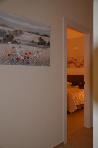 a painting hanging on a wall next to a bedroom at Ferriera 8 in Novi Ligure