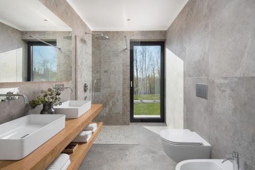 a bathroom with two sinks and a toilet at Villa Ulmus in Karojba