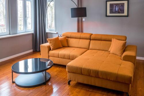 - un salon avec un canapé et une table dans l'établissement AH Apartamenty - Park, à Ełk