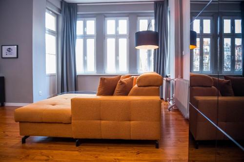 - un salon avec un lit et un canapé dans l'établissement AH Apartamenty - Park, à Ełk