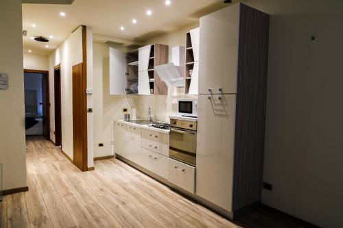 una cucina con mobili bianchi e un forno a piano cottura di Juliet Deluxe Apartment a Verona