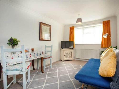 a living room with a table and a tv at Waterside Park Annex in Kingsbridge