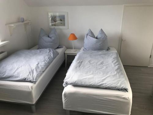 2 Betten mit Kissen auf einem Zimmer in der Unterkunft Ferienwohnung Sonnendeck in Eckernförde