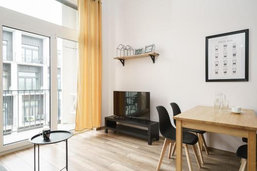a living room with a dining room table and a television at RentPlanet - Apartamenty Zarembowicza in Wrocław