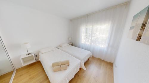 ミハスにあるMiraflores Penthouse Green Surroundingsの白いベッドルーム(ベッド1台、窓付)