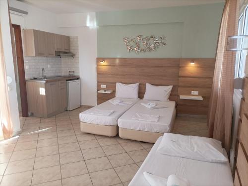 um quarto de hotel com duas camas e uma cozinha em Filomeni Studios em Pefkohori