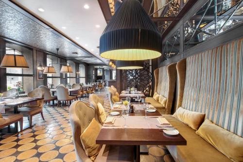 restauracja z długim stołem i krzesłami w obiekcie Metropole Hotel by Semarah w Rydze