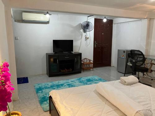 a living room with a bed and a tv and a room at Cassiarata in Phnom Penh