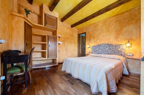 a bedroom with a bed and a table and a desk at Lo paller in Perelló