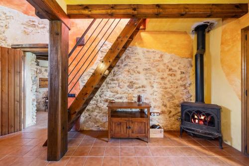 a fireplace in a room with a stone wall at Lo paller in Perelló