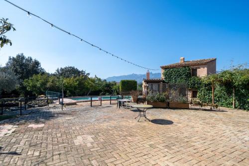 a patio with a pool and a table and a building at Lo paller in Perelló