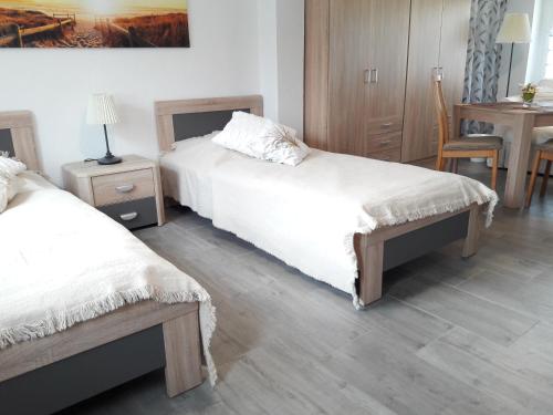 a bedroom with two beds and a table with a chair at Ferienwohnung "Jasmund" in Sagard auf Rügen in Sagard