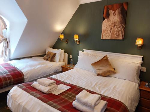 a bedroom with two beds with towels on them at The Norwood in Torquay