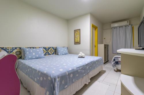 a bedroom with a bed with a blue comforter at Pousada Kanamary in Praia do Frances
