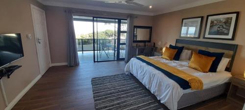 a bedroom with a large bed and a balcony at Collards B&B in Durban