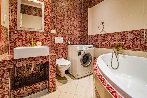 a bathroom with a tub and a toilet and a washing machine at Astronomical Clock Suite by Ruterra in Prague