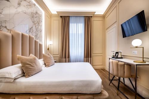 Hotel Emma Small Luxury Hotel في فلورنسا: غرفة في الفندق مع سرير ومكتب