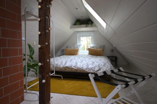 una cama en el ático de una casa pequeña en Idyllisches Wohnen in grüner Oase, en Griesheim