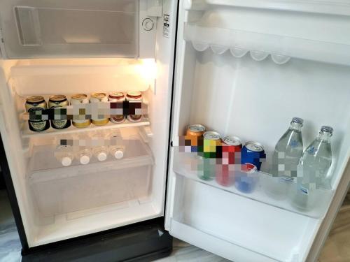 an open refrigerator filled with bottles and drinks at Baan Thanakul Residences in Samutprakarn