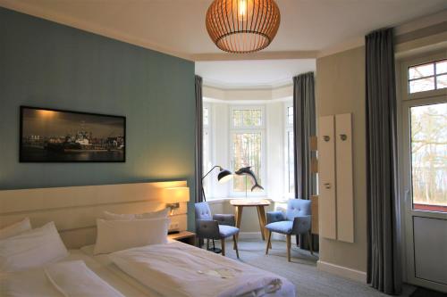 a hotel room with a bed and a table and chairs at Hotel Wehrburg in Cuxhaven