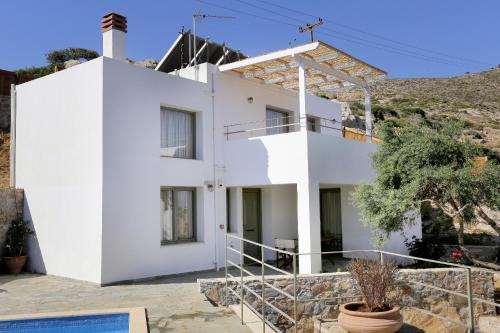 a white house with a hill in the background at Mourtzanakis Residence - Traditional Eco Hotel in Achlada in Achlada