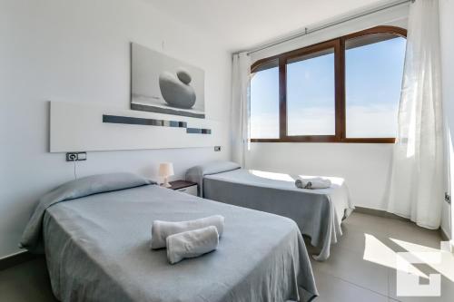 1 dormitorio con 2 camas y ventana grande en Villa Mirador de Bassetes 14 - Grupo Turis en Calpe