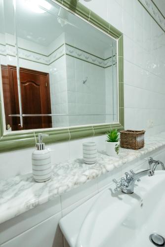 a white bathroom with a sink and a mirror at LAR DA REVOLTA in Cedeira