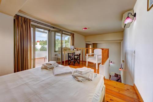 - une chambre avec un grand lit blanc et une salle à manger dans l'établissement Mourtzanakis Residence - Traditional Eco Hotel in Achlada, à Achlada