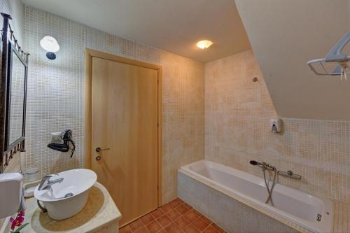 a bathroom with a sink and a tub and a toilet at Mourtzanakis Residence - Traditional Eco Hotel in Achlada in Achlada