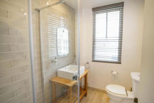 a bathroom with a toilet and a sink and a shower at Woodyear House - Cowes - Sleeps 8 - 4 Bed - Dog Friendly - Waterfront in Cowes