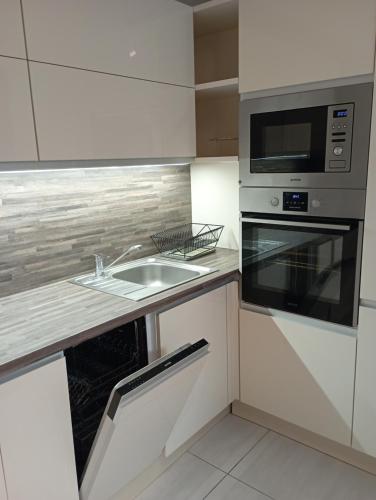 a kitchen with a sink and a microwave at Apartments Captain Grand Prague in Prague