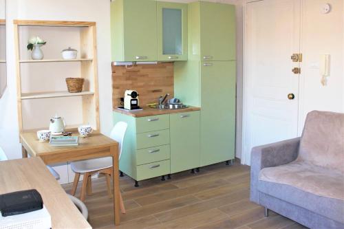 - un salon avec un lavabo dans un meuble vert dans l'établissement Studio DolceCasa Menton, à Menton