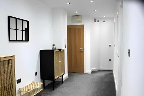 a hallway with a brown door and a bench at Contemporary Comfort - Central Bradford Flat in Bradford