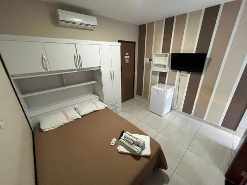 a small room with a bed and a television at Sâmily Hotel in Currais Novos