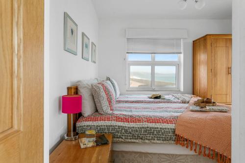 a bedroom with a bed and a window at 3 At The Beach, Torcross in Beesands