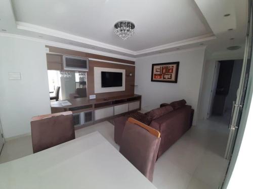 ein Wohnzimmer mit einem Sofa und einem Tisch in der Unterkunft Apartamento inteiro com garagem coberta Treviso in União da Vitória