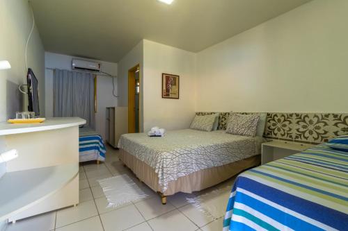 a small bedroom with a bed and a couch at Pousada Kanamary in Praia do Frances