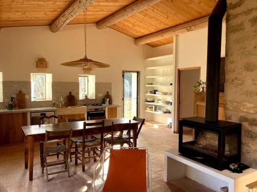 Il comprend une cuisine et une salle à manger avec une table et une cheminée. dans l'établissement Maison à Aix en provence au pied de la Sainte Victoire, à Beaurecueil