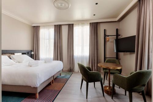 une chambre d'hôtel avec un lit, une table et des chaises dans l'établissement Gogaille - Corneille - Accès autonome, à Tours
