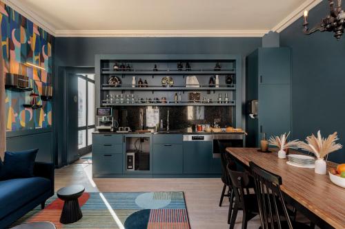 Gogaille - Corneille - Accès autonome في تور: مطبخ بجدران زرقاء وطاولة خشبية