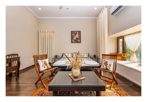 1 dormitorio con 1 cama, mesa y sillas en Tranquility homestay, en Shivpurī