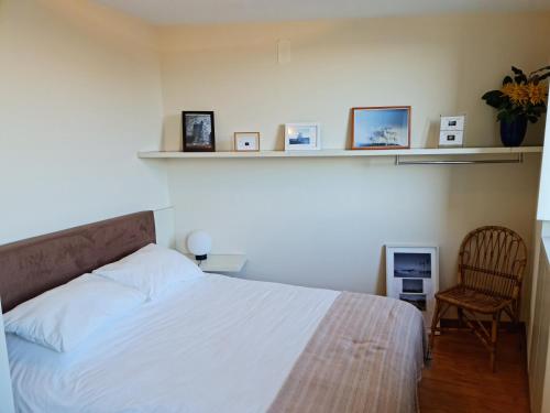 a bedroom with a bed and a chair and shelves at Casa na Fraga in Aldeia das Dez