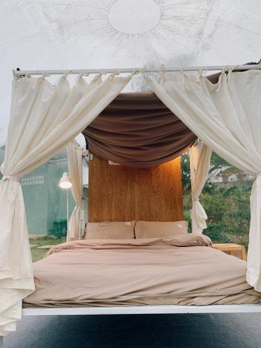 a bed with a canopy in a room at Lacasa home&coffee Mộc Châu in Mộc Châu