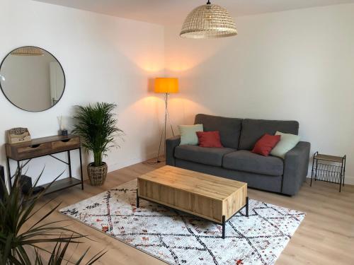 uma sala de estar com um sofá e uma mesa de centro em Appartement T2 lumineux et cosy au calme proche du centre avec TV Netflix et Wifi em La Rochelle