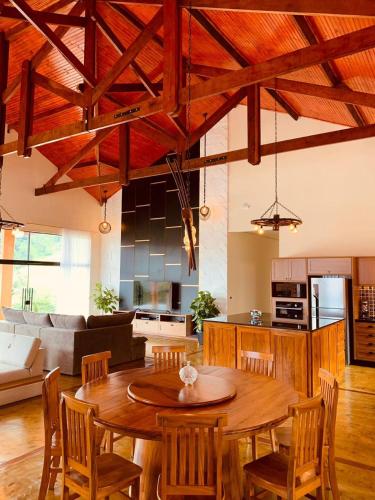 a living room with a wooden table and a kitchen at Chacara Belo Encanto in Santo Antônio do Pinhal