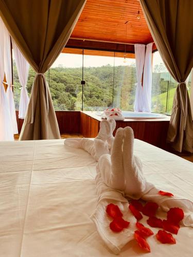 a bed with a pile of red roses on it at Chacara Belo Encanto in Santo Antônio do Pinhal